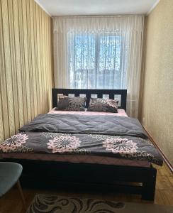 - une chambre avec un grand lit et une fenêtre dans l'établissement 4-км в центрі міста, à Rivne