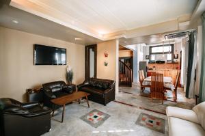 a living room with leather furniture and a dining room at Thai Authentic House in Jomtien Beach