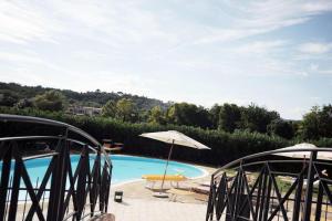 - Piscina con sombrilla, sillas y mesa en Lago di Garda a 300m House in Manerba, en Manerba del Garda