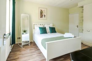 a bedroom with a large white bed with blue pillows at P&M Happy Bungalow in Sunbury Common