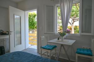 uma cozinha com uma mesa e uma janela e uma mesa e cadeiras em Skypiea Room em Agia Anna (Naxos)