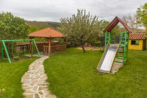 un parque con tobogán y un parque infantil con casa en Екокомплекс Катунище en Katunishte
