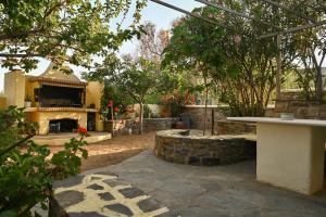 a backyard with a fireplace and a stone patio at Skypiea Room in Agia Anna Naxos