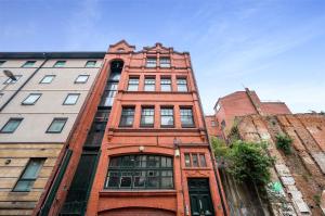 un grand bâtiment en briques rouges avec des fenêtres sur une rue dans l'établissement Host & Stay - Bands Warehouse VI, à Liverpool
