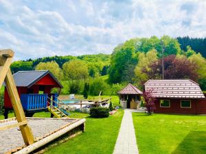 een tuin met twee kleine gebouwen en een huis bij GREEN LAND Family Fun Sport Resort in Šmarje pri Jelšah