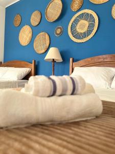 1 dormitorio con 2 camas y pared azul en Pousada Mawe en Parati