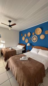 um quarto com 2 camas e uma parede azul em Pousada Mawe em Paraty