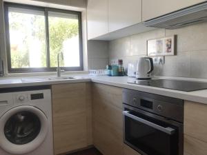 a kitchen with a washing machine and a sink at Farm stay in Maceira, Leiria 