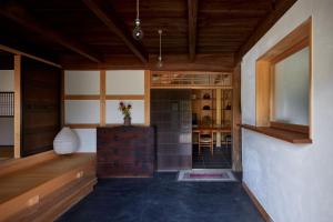 Zimmer mit Holzdecken und einem Tisch in der Unterkunft Casa KitsuneAna The Satoyama experience in a Japanese-style modernized 100-year-old farmhouse in Akaiwa