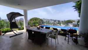 a patio with a table and chairs and a pool at YALIKAVAK VILLA MAGNOLIA in Bodrum City