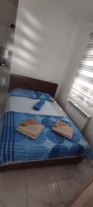 a bedroom with a bed with two towels on it at Apartmani Bar in Bar