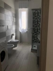 een badkamer met een toilet, een wastafel en een raam bij Casa Estiva Francesco e Nicolò in Vieste