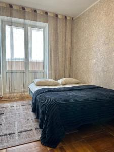 a bedroom with a bed in a room with two windows at 4-км в центрі міста in Rivne