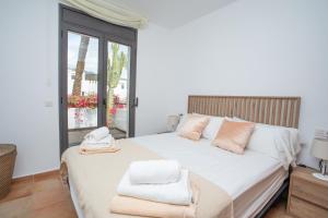 een slaapkamer met een groot wit bed en handdoeken bij Casa del Mar in Mojácar