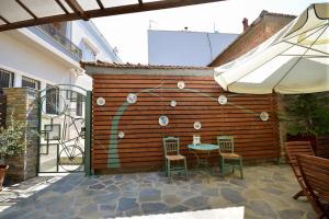 a patio with a table and chairs next to a wooden wall at Two-storey house with loft at Agria,Volos in Agria