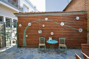 a patio with two chairs and a table in front of a wooden wall at Two-storey house with loft at Agria,Volos in Agria