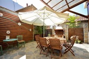 a patio with an umbrella and a table and chairs at Two-storey house with loft at Agria,Volos in Agria