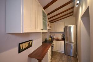 a kitchen with white cabinets and a stainless steel refrigerator at Two-storey house with loft at Agria,Volos in Agria