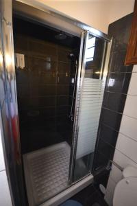 a shower with a glass door in a bathroom at Two-storey house with loft at Agria,Volos in Agria +33 photos