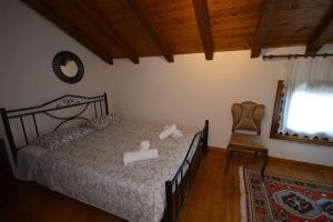 a bedroom with a bed and a chair and a window at Two-storey house with loft at Agria,Volos in Agria