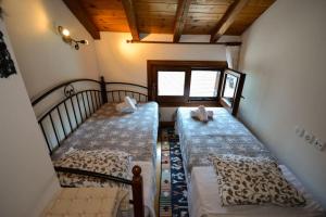 a bedroom with two beds and a window at Two-storey house with loft at Agria,Volos in Agria