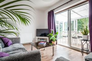 a living room with a couch and a tv at P&M Happy Bungalow in Sunbury Common