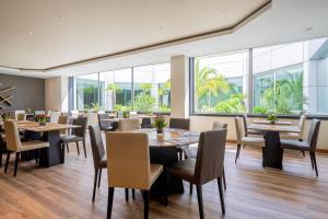 a restaurant with tables and chairs and large windows at HF Ipanema Park in Porto