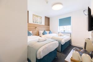 una habitación de hotel con dos camas y una ventana en Griffin House Hotel, en Londres