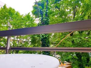 ein Surfbrett auf einer Bank vor Bäumen in der Unterkunft ''Le Verlaine'' T2 au cœur de l'agglomération Lyonnaise in Villeurbanne