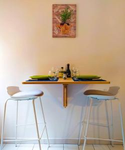 une table avec des chaises, des assiettes et des verres dans l'établissement ''Le Verlaine'' T2 au cœur de l'agglomération Lyonnaise, à Villeurbanne