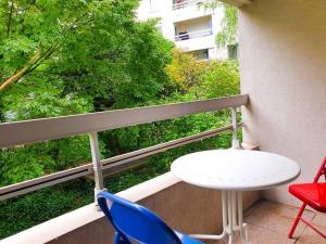 d'une table blanche et de deux chaises sur un balcon. dans l'établissement ''Le Verlaine'' T2 au cœur de l'agglomération Lyonnaise, à Villeurbanne