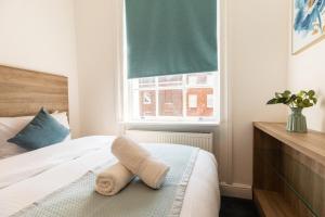un dormitorio con una cama con una toalla encima en Griffin House Hotel, en Londres