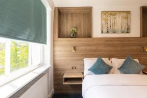 un dormitorio con una cama blanca y una ventana en Griffin House Hotel, en Londres