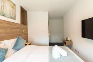 un dormitorio con una cama blanca y un televisor de pantalla plana en Griffin House Hotel, en Londres 31 fotos más
