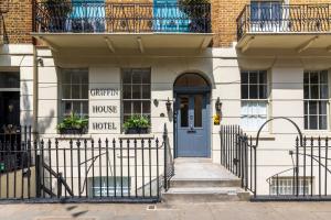 una casa con una puerta azul y un cartel en ella en The Chapter - Griffin House Hotel, en Londres