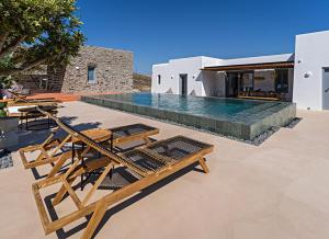 una piscina con sillas y una villa en Cape Ftelia en Ftelia