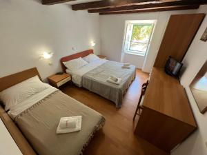 a small bedroom with two beds and a television at Apartments Valentino by Pag tours in Pag