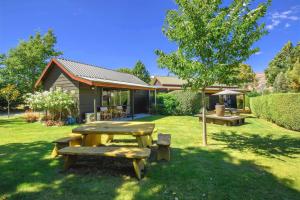 una mesa de picnic y un banco en un patio en Alpine View Lodge, en Wanaka