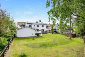 um quintal aberto com uma casa branca ao fundo em Luxurious apartment for the modern executive em Luleå