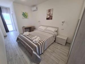 ein Schlafzimmer mit einem Bett mit zwei Handtüchern darauf in der Unterkunft Civico 14 Apartment 4B in Monserrato