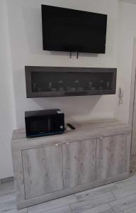 TV a schermo piatto in cima a un armadio in legno di Civico 14 Apartment 4B a Monserrato