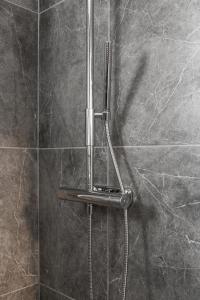 y baño con ducha con cabezal de ducha. en Luxurious apartment for the modern executive en Luleå