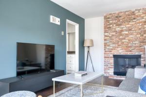 a living room with a fireplace and a brick wall at Westwood 1BR w Rooftop nr Westwood Village LAX-111 in Los Angeles