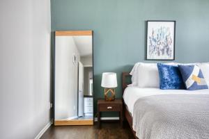 um quarto com uma cama com paredes azuis e um espelho em Westwood 1BR w Rooftop nr Westwood Village LAX-111 em Los Angeles