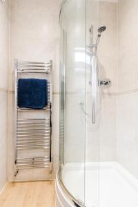 bagno con doccia e porta in vetro di P&M Happy Bungalow a Sunbury Common