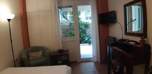 una camera d'albergo con un letto, una sedia e una finestra di Cozy studio 5mins walk from Acropolis museum ad Atene