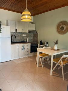 cocina con mesa y nevera blanca en Niko Summer House, en Sozopoli