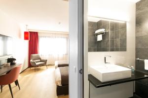 a hotel bathroom with a sink and a room at Bastion Hotel Amersfoort in Amersfoort