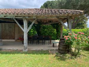 a wooden gazebo with a table and chairs at Les Séchoirs in Clairac