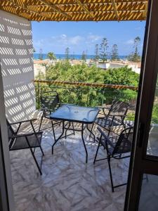 d'une terrasse avec une table et des chaises sur un balcon. dans l'établissement Spacious 3 bedroom apartment with a sea view., à Dawwār Abū Maḩrūs